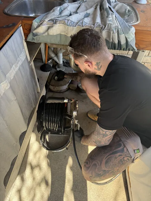 plumber using CCTV camera to inspect old pipes in Warner