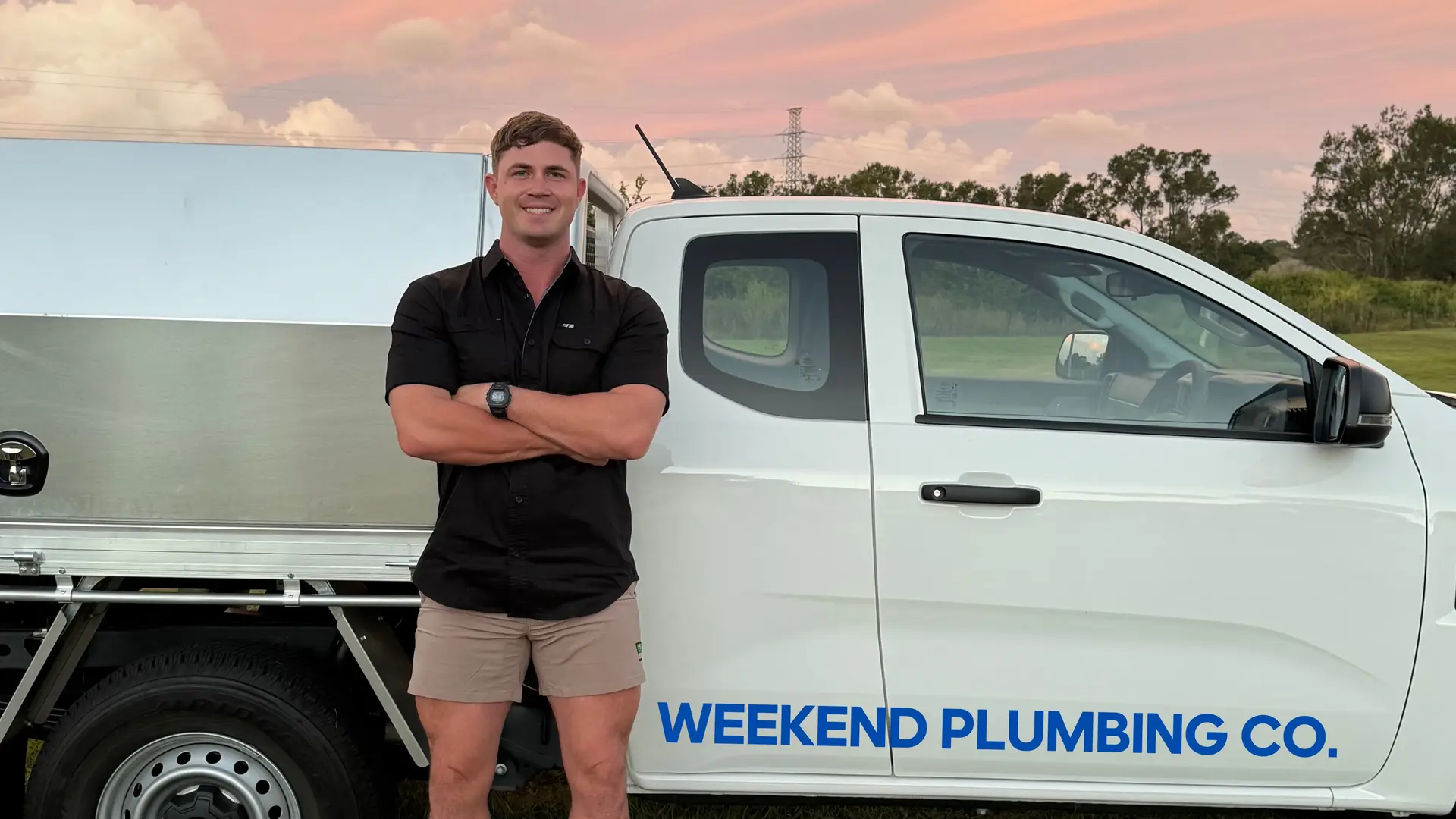 Weekend Plumbing Co blocked drain plumber standing next to branded work ute in Brisbane