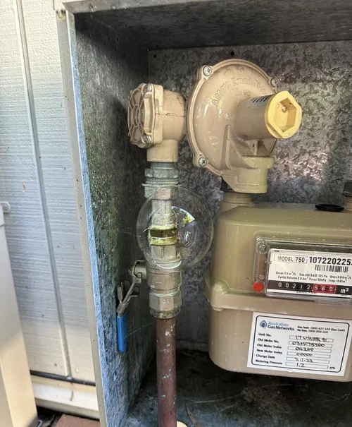 Soap bubble forming at a gas pipe joint during a leak test on a Brisbane home's natural gas meter
