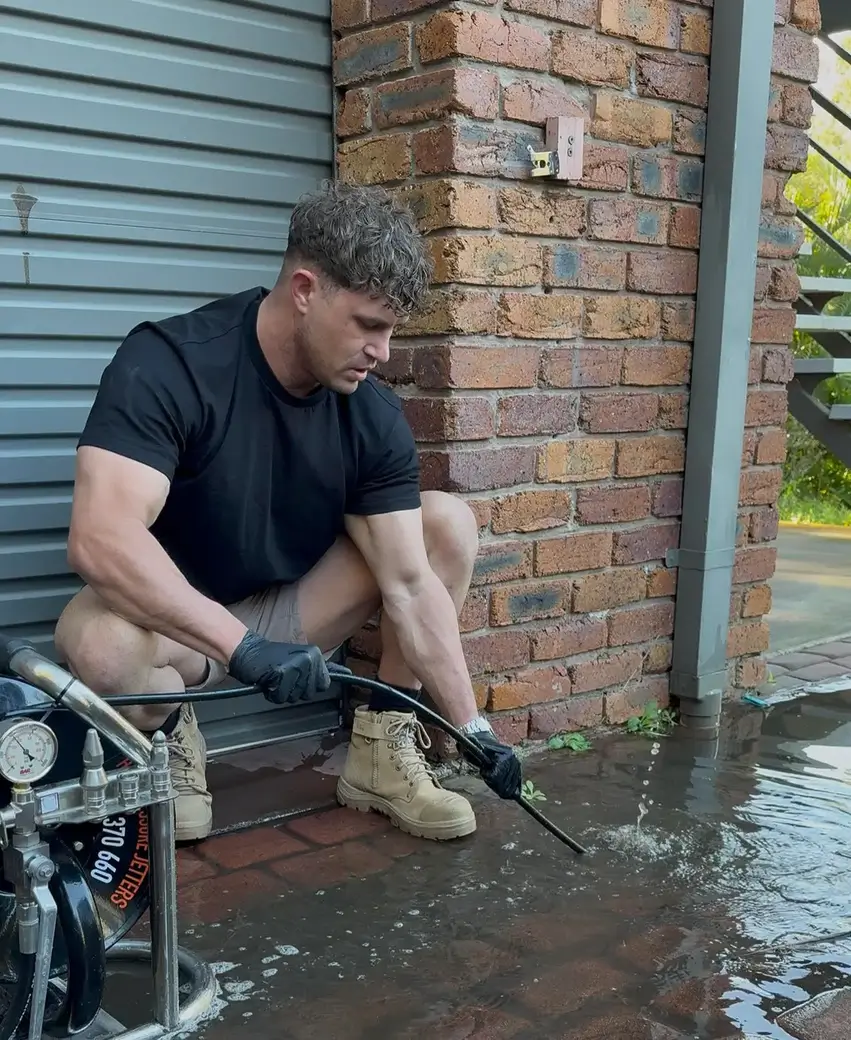 plumber jet blasting a blocked drain in Brisbane