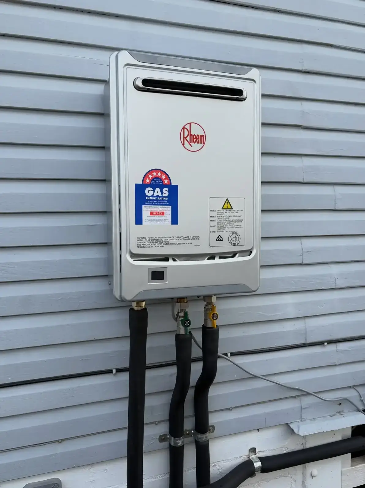 Rheem continuous flow gas hot water system wall-mounted on a weatherboard exterior at an Brisbane home